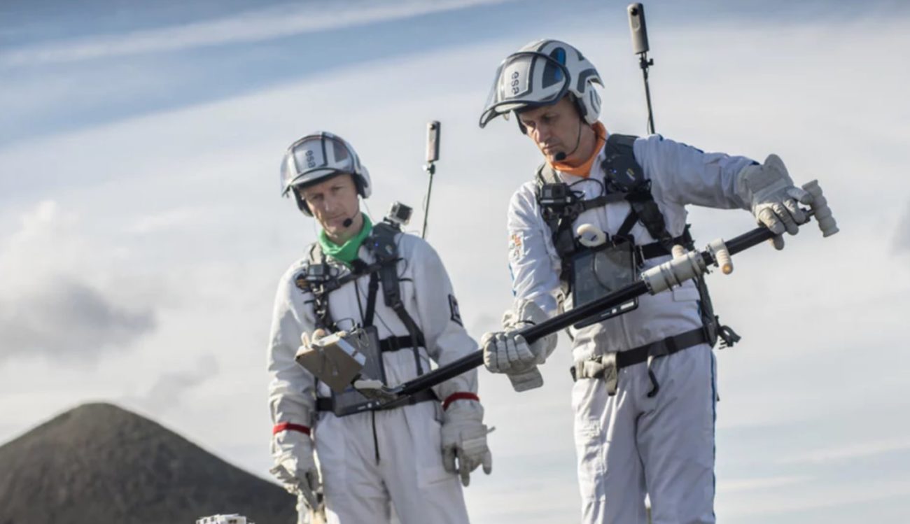 Los astronautas de la practica de luna paseos en la superficie de los volcanes