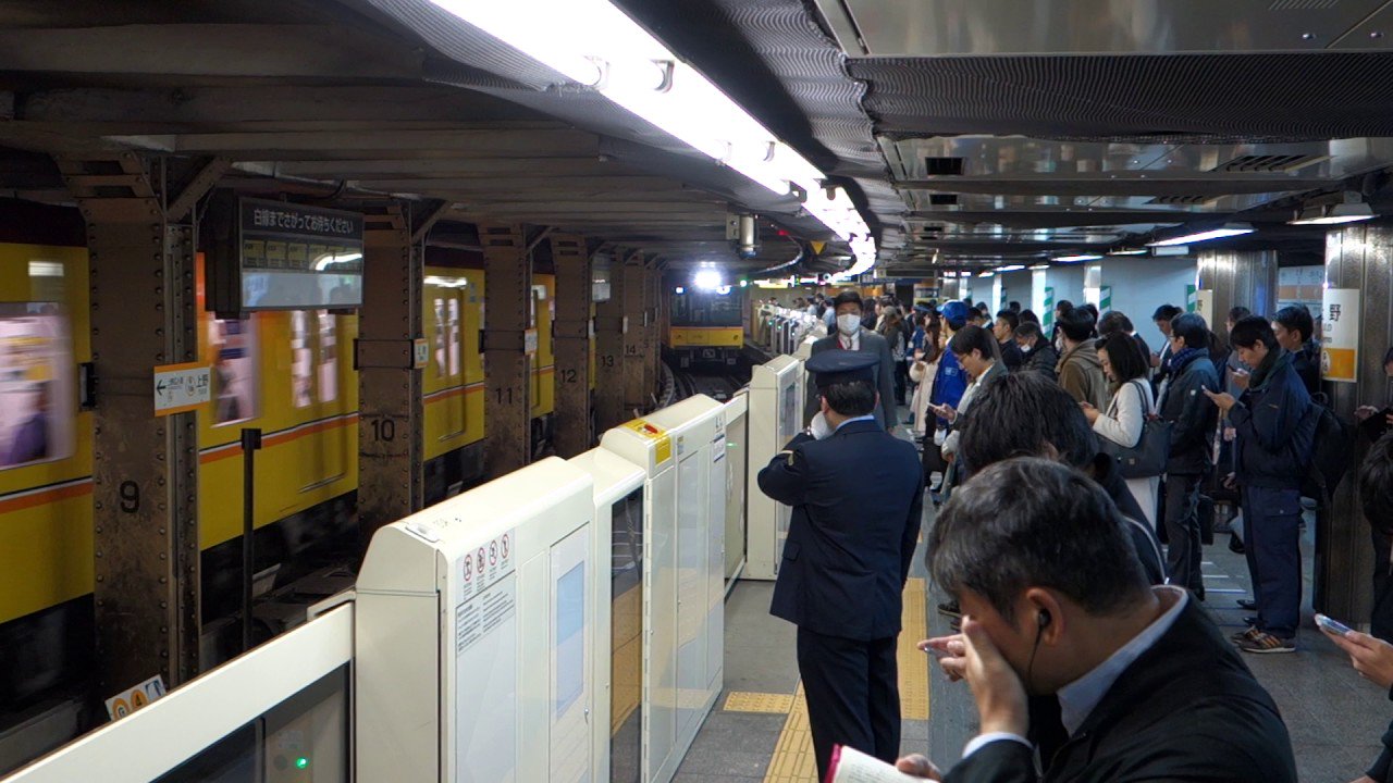 Die Passagiere der Tokyoter U-Bahn helfen werden die Roboter